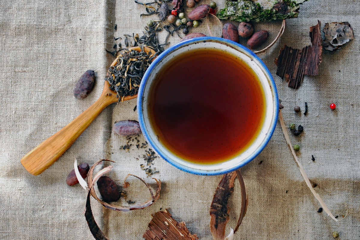 A cup of spiced tea surrounded by whole spices